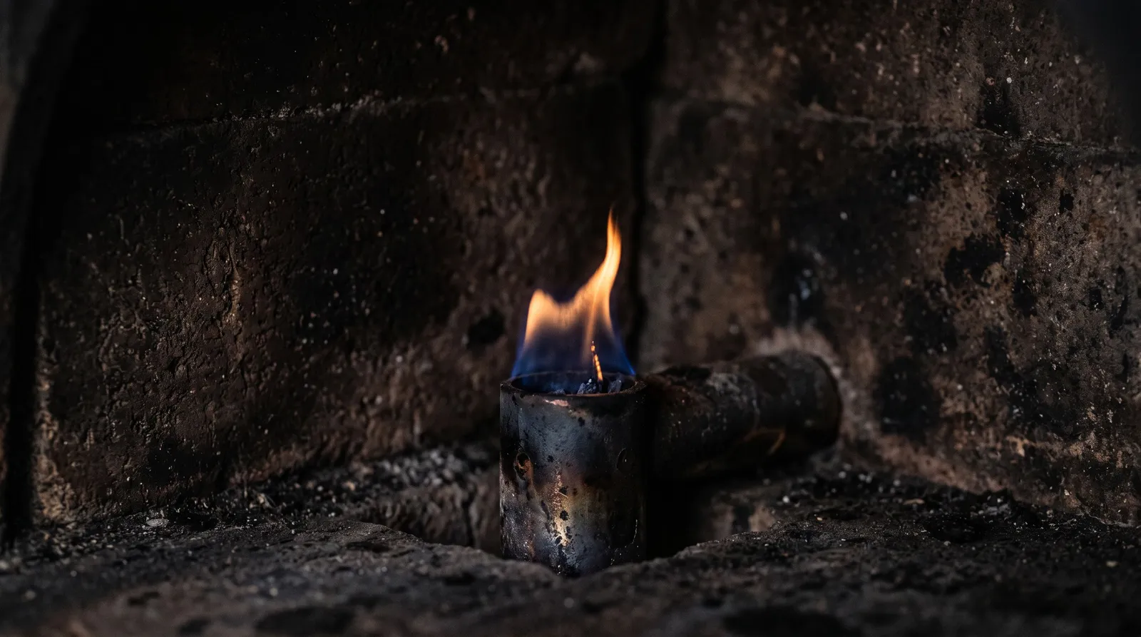 Flamme faible et vacillante d'un brûleur à gaz de four à pizza, prête à s'éteindre