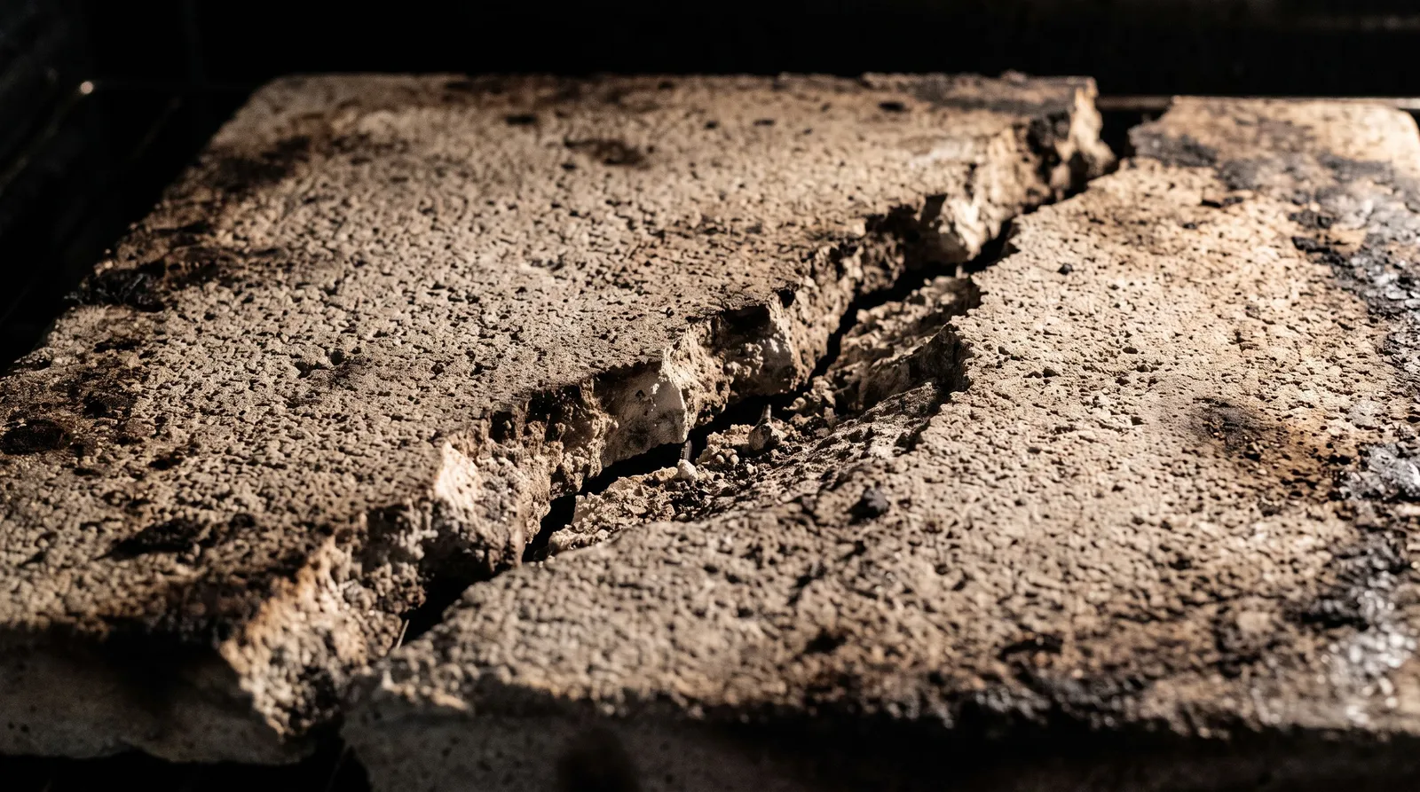 Fissure traversant la surface d'une sole en pierre réfractaire de four à pizza